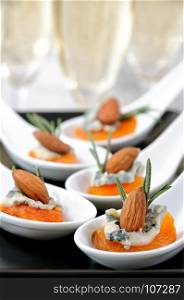 Cocktail snack from dried apricots with gorgonzola and almonds