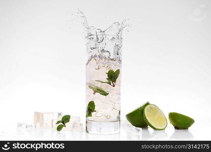 cocktail splashing into glass and cube of ice