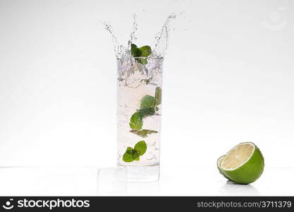 cocktail splashing into glass and cube of ice