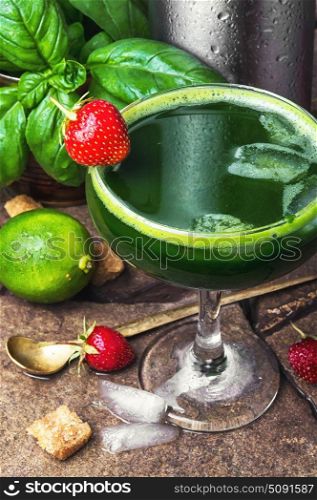 cocktail with basil leaves and strawberry. Alcoholic cocktail with basil and strawberries on a stone background