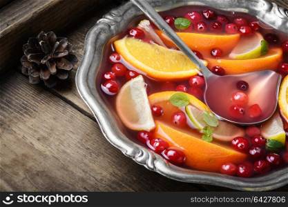 Cocktail with fruits and berries. Alcoholic cocktail with pieces of fruit and berries in a bowl