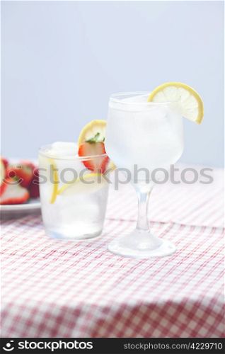 cocktail with ice,lemon and strawberries on a plate