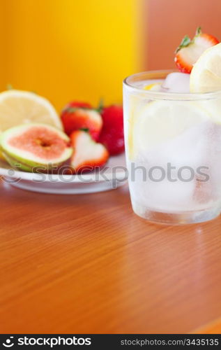 cocktail with ice,lemon, fig and strawberries on a plate