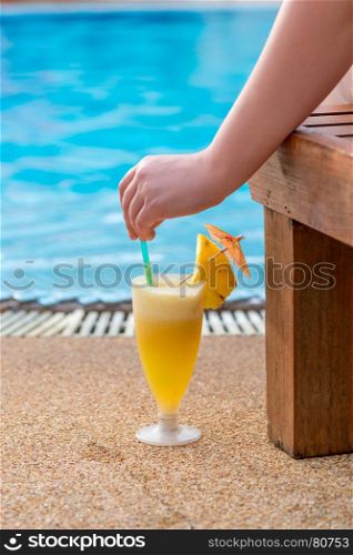 cocktail, woman's hand and view of the pool in the tropics