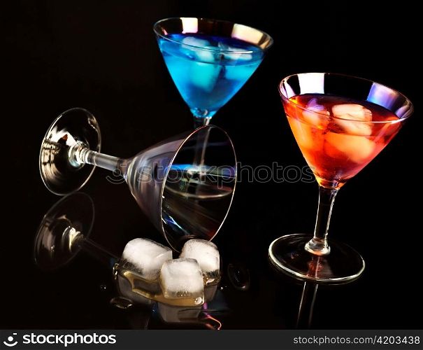 cocktails with ice cubes on black background