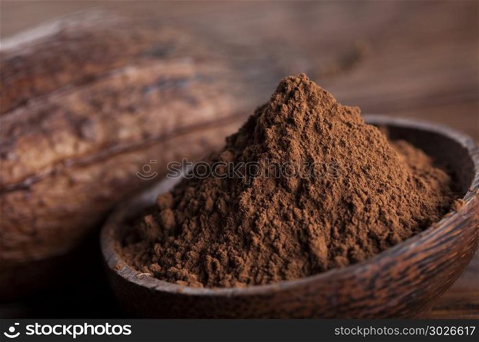 Cocoa beans in the dry cocoa pod fruit on wooden background. Cacao beans and powder and food dessert background