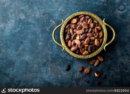 Cocoa beans on dark background, top view, copy space, flat lay