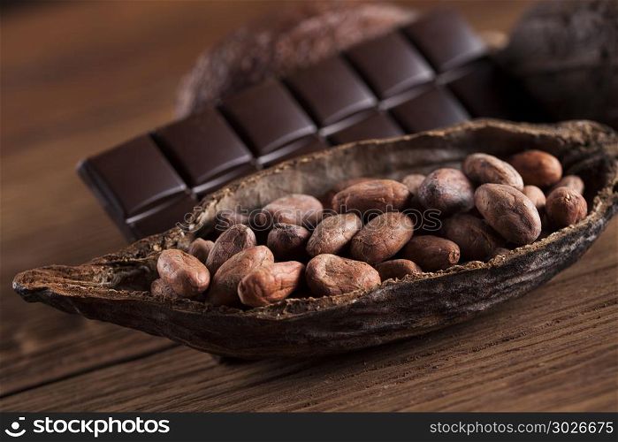 Cocoa pod and cocoa beans on the wooden table. Cocoa pod on wooden background