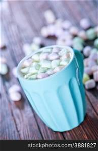 cocoa with marshmallow in cup and on a table
