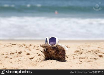 Coconut and a sunglasses on a beautiful beach. India Goa.. Coconut and a sunglasses on a beautiful beach. India Goa