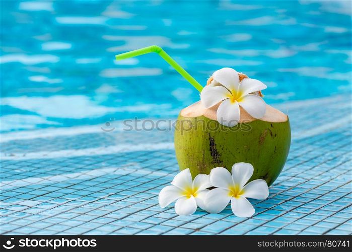 coconut and flowers of plumeria on the edge of the pool composition