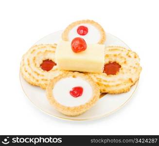 Coconut and jam biscuits with slice of cake and cherry on top. Isolated over white background.