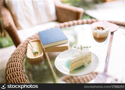 Coconut Cake and Coffee in a cafe on the blur background. traditional dessert Sliced of delicious coconut layer cake.