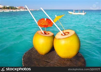 coconut coktails in caribbean on wood pier turquoise sea