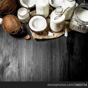Coconut milk in bottles. On a black wooden background.. Coconut milk in bottles.
