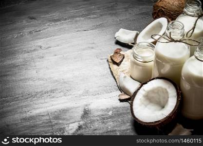 Coconut milk in bottles. On a black wooden background.. Coconut milk in bottles.