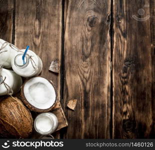 Coconut milk in bottles. On a wooden table.. Coconut milk in bottles.