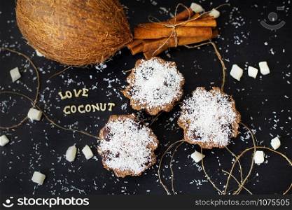 coconut muffins on a black background inscription love coconuts, close-up. coconut muffins on a black background
