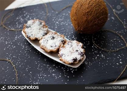 coconut muffins with chocolate on a black background and whole coconut. coconut muffins on a black background