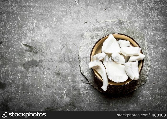 Coconut pulp in a bowl . On a stone background.. Coconut pulp in a bowl .