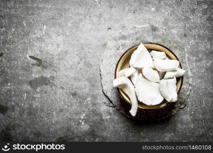 Coconut pulp in a bowl . On a stone background.. Coconut pulp in a bowl .