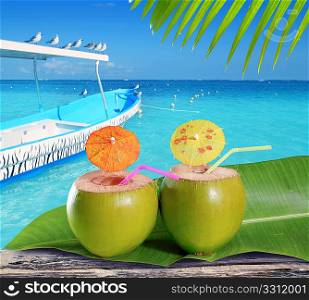 coconuts straw cocktails in tropical caribbean turquoise beach with boat