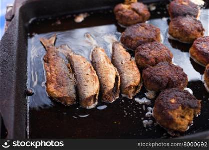 Cod (Dorsch) filets and frikadeller (frikadelle) cooking in oil