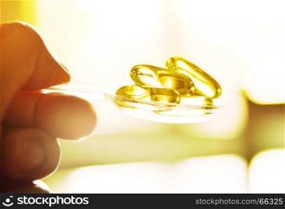 Cod liver oil omega 3 gel capsules in the spoon. Medicine, Medical health care, Healthy Food