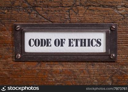 code of ethics - file cabinet label, bronze holder against grunge and scratched wood
