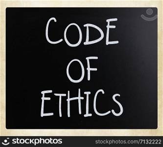 ""Code of ethics" handwritten with white chalk on a blackboard"