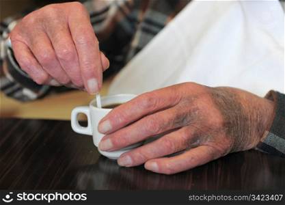 coffe cup and old hand on a table