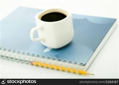 coffe cup, yellow pencil and spiral notebook