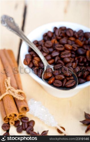 coffe sugar and spice on silver spoon over white wood rustic table
