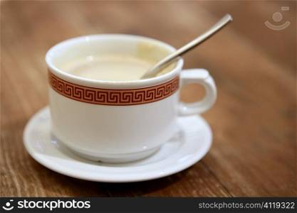 Coffe with milk white cup over teak wooden