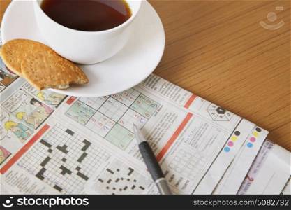 Coffee and biscuits with newspaper crossword
