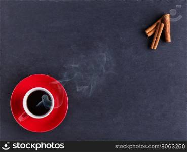 Coffee and cinnamon sticks on black table. Coffee and cinnamon sticks