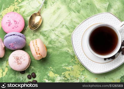 coffee and colorful macaroons. coffee and colorful French macaroons on green background