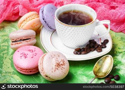 coffee and macaroons. coffee and colorful French macaroons on green background
