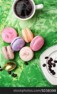 coffee and macaroons. coffee and colorful French macaroons on green background