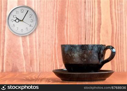 Coffee and wall clock on the wooden background