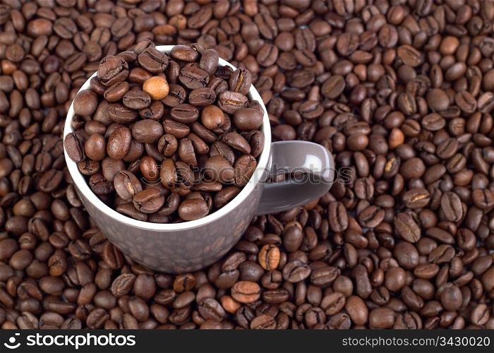Coffee Bean Background with cup. High resolution file full of coffee beans with a cup full of beans on the left