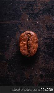 Coffee bean in a closeup macro on a dark background, top view