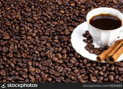Coffee beans and a cup of coffee with cinnamon. Horizontal view