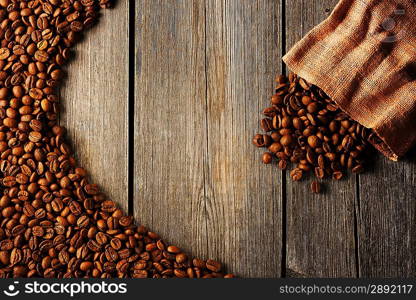 Coffee beans and bag over wooden background