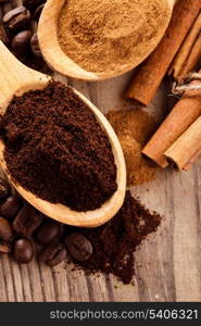 Coffee beans and cinnamon milled closeup in wooden spoons