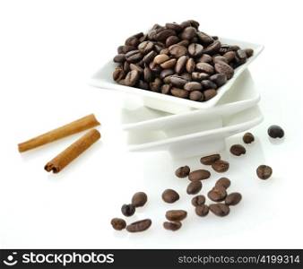 coffee beans and cinnamon sticks on white background