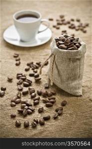 coffee beans and cup of coffee on sacking