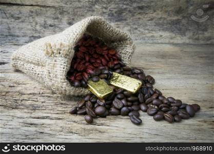 Coffee beans and Gold Bullion in sackcloth bag on wooden background