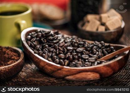 Coffee beans and ground coffee in wooden bowl on table. Making coffee concept
