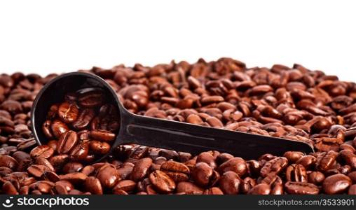 coffee beans and measuring spoon against white background